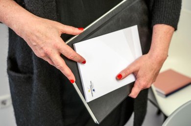 العمل المكتبي امرأة تحمل ملفاً ومفكرة.