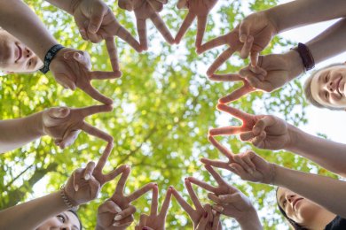 نجمة اليد الشباب يشكلون نجمة بإصبعين مفرودتين معًا