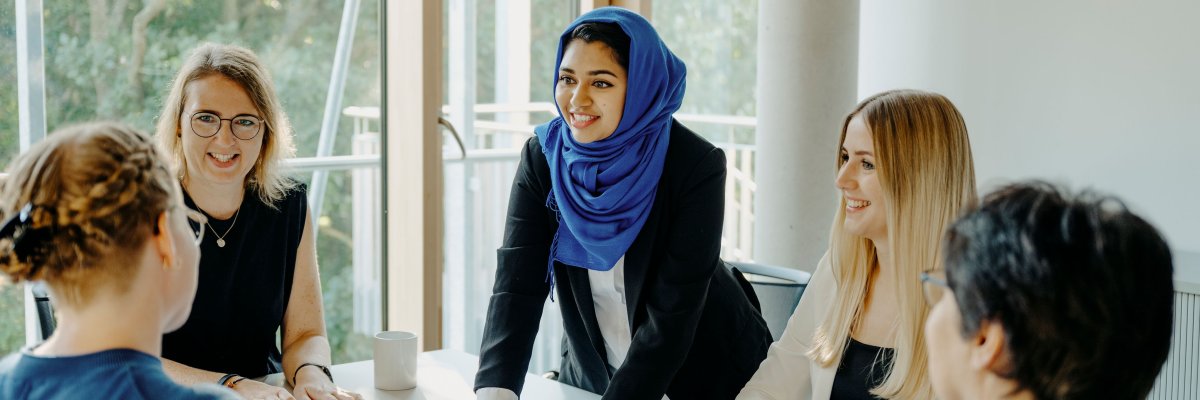 ثلاث نساء يجلسن على طاولة يضحكن.