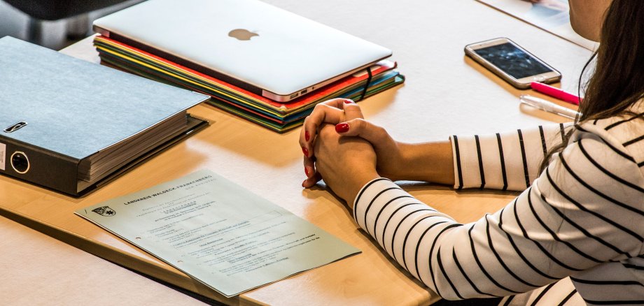 امرأة تجلس على طاولة مع وثائق الاجتماع