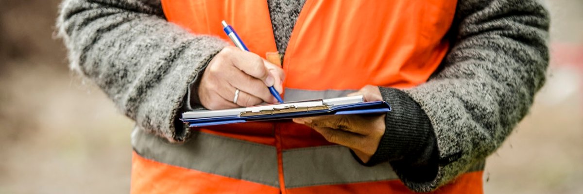 A construction worker takes notes