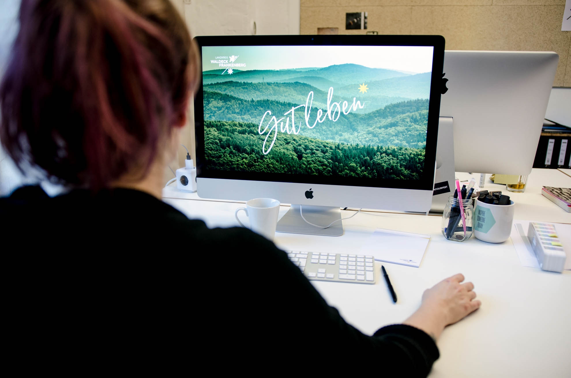 Computer screen office A woman sits in front of a computer.