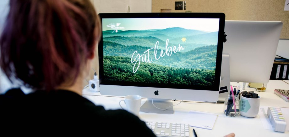 A woman sits in front of a computer.