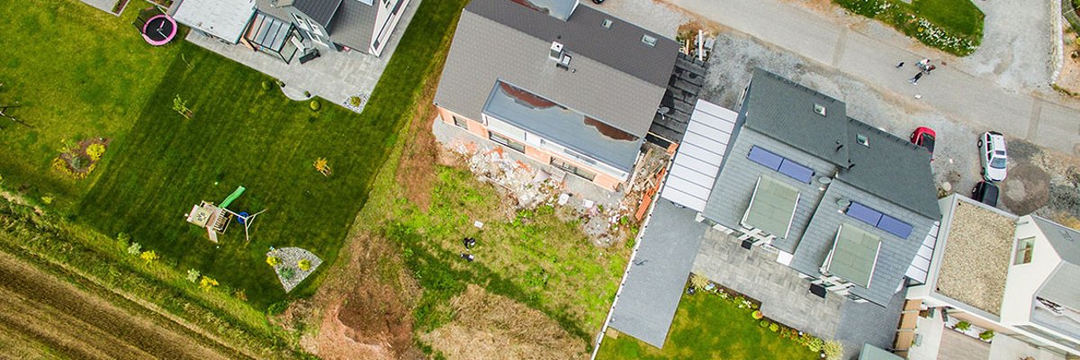 Aerial view of three detached houses with gardens