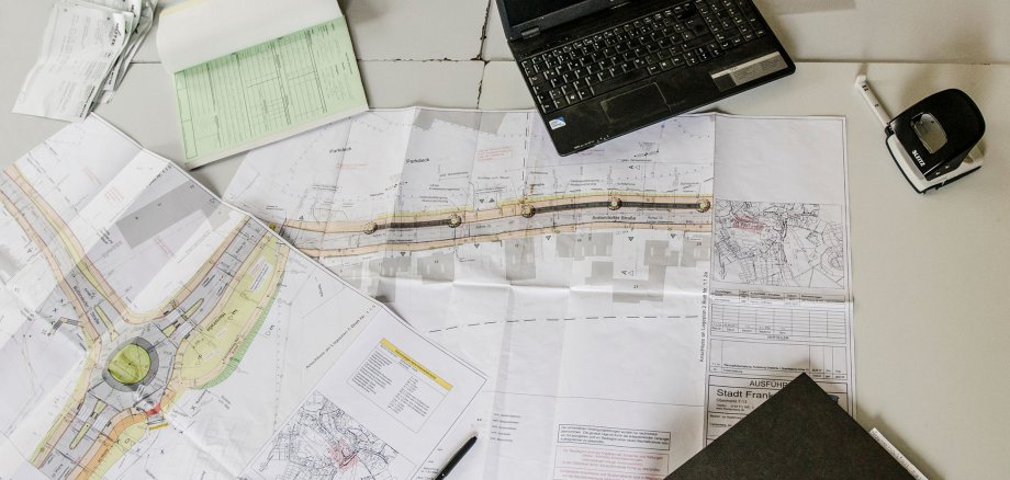 Many construction plans are on a table
