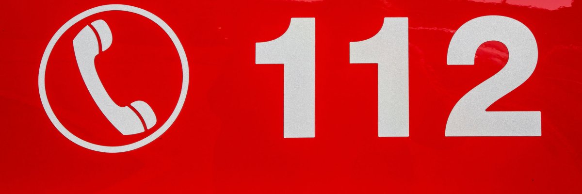 White telephone symbol and emergency number 112 on red background