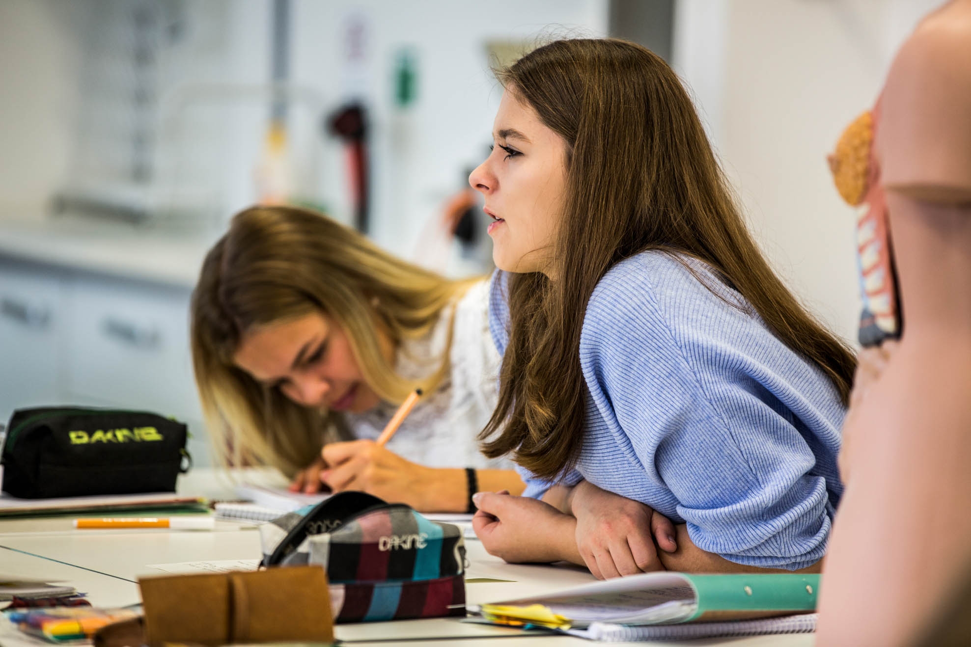 Two schoolgirls listening to the lesson