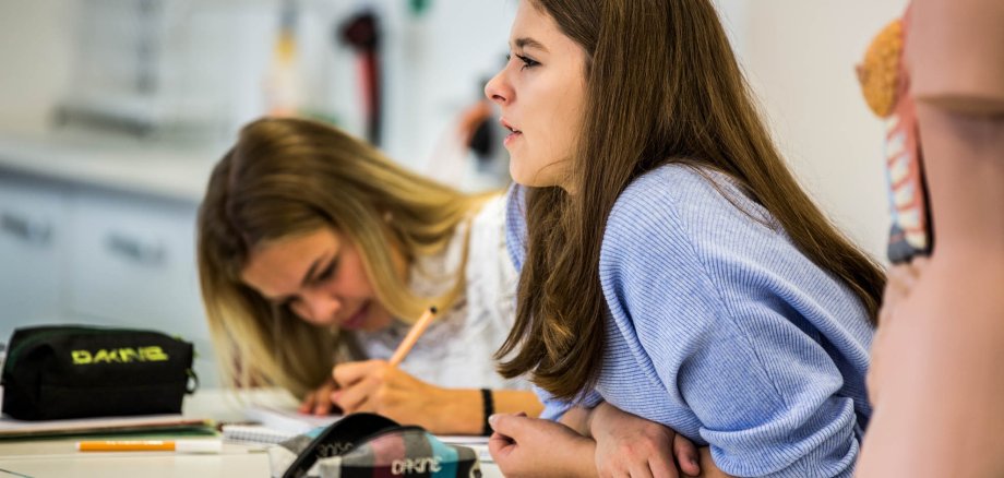 Two schoolgirls listening to the lesson