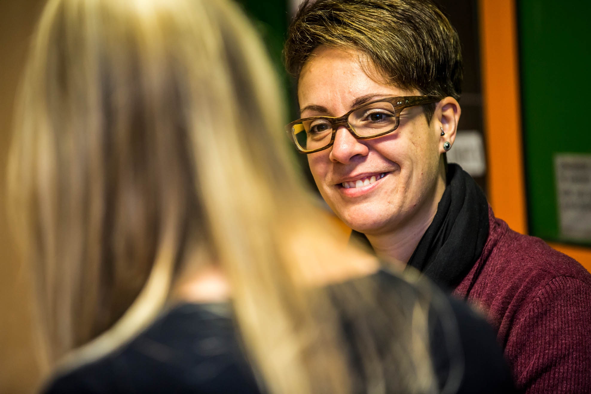Conversation school social work A woman with glasses is smiling and talking to a student