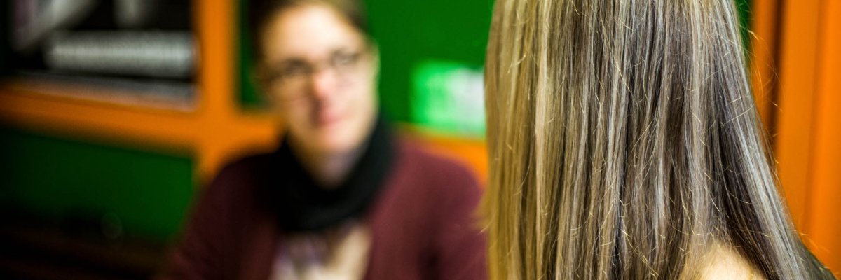 Back view of a pupil, a woman blurred in the background