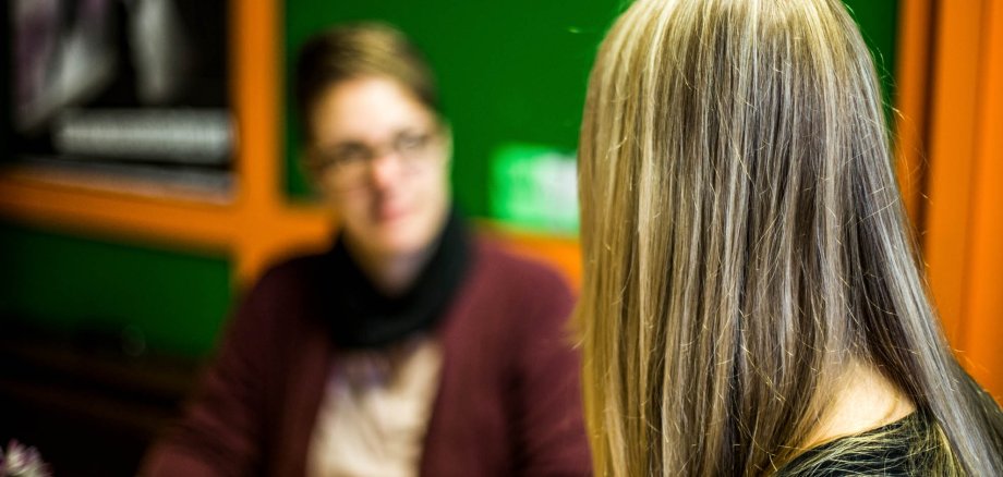 Back view of a pupil, a woman blurred in the background