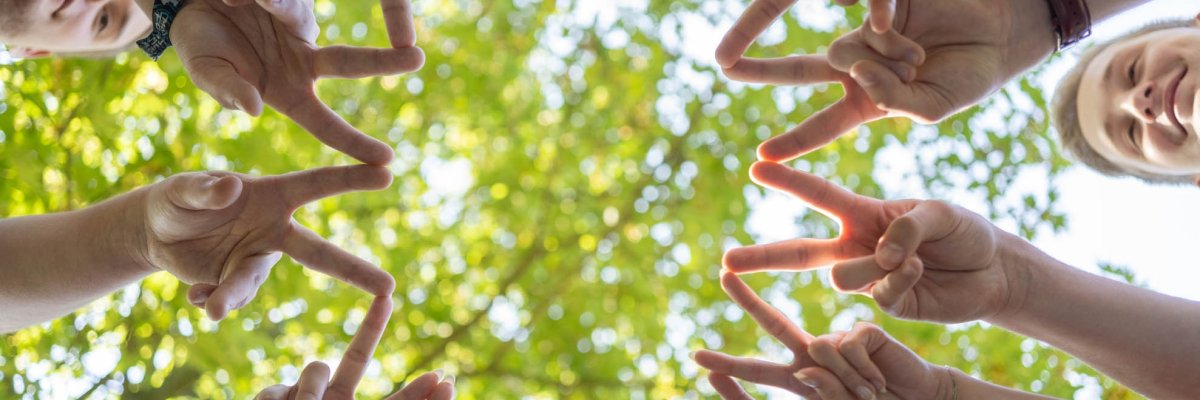 Young people form a star with two fingers spread apart.