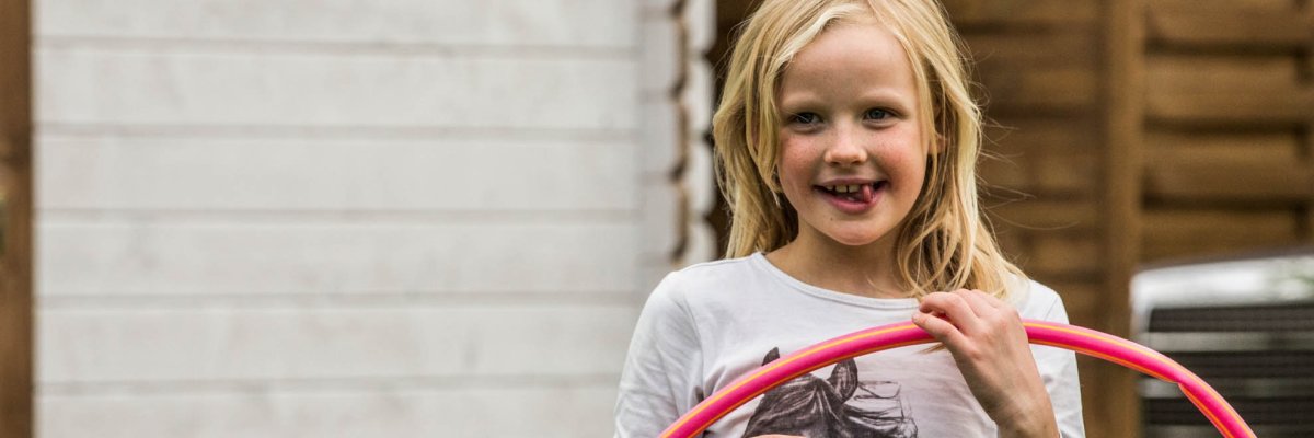 A girl holds a red hoop