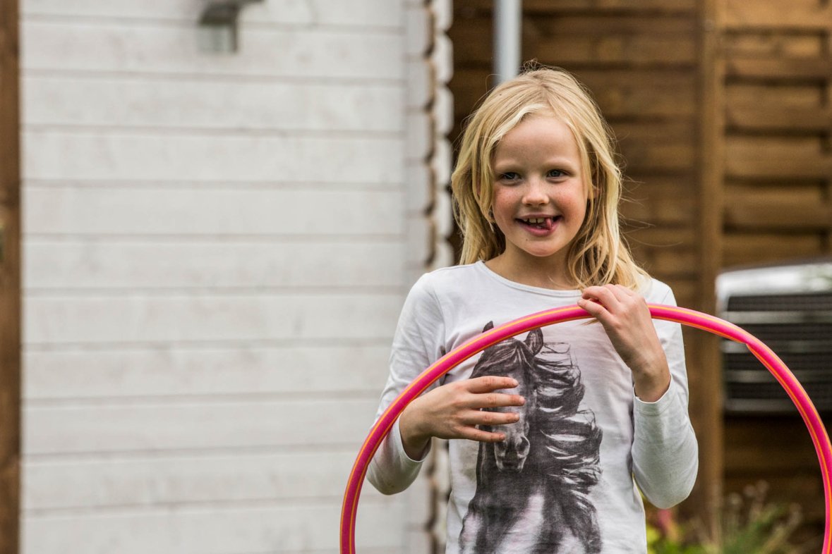 A girl holds a red hoop