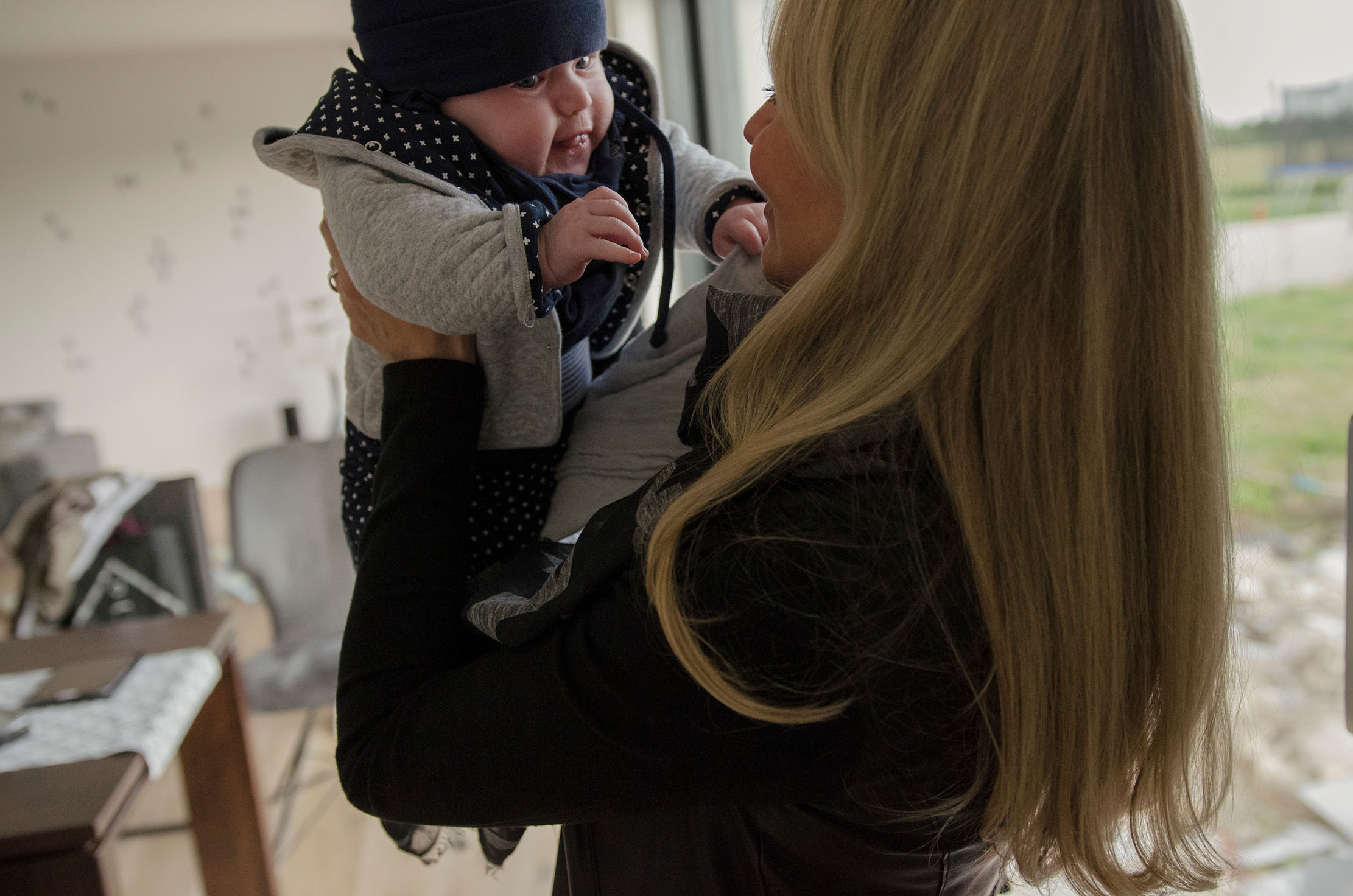 A mother holds up her baby