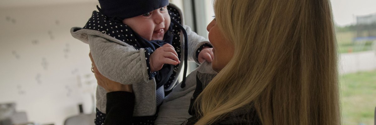 A mother holds up her baby