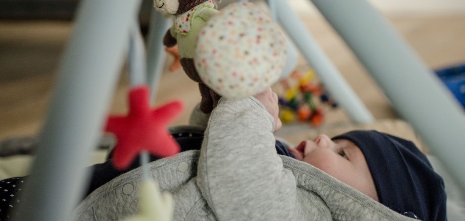A baby plays with a mobile