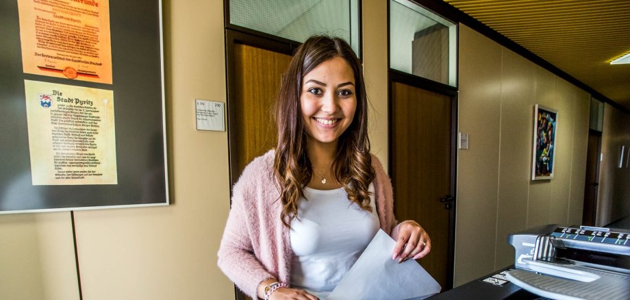 Smiling young woman at a photocopier