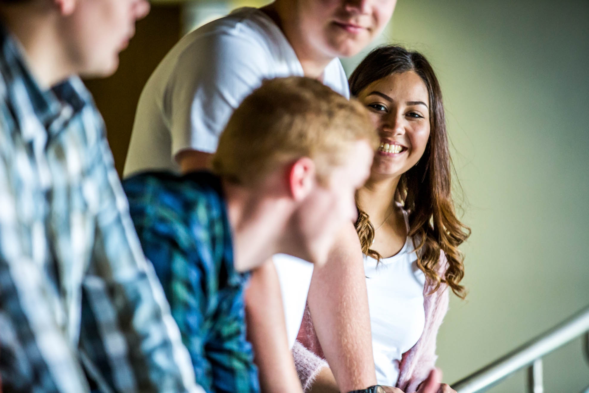 Four smiling young people in the office corridor