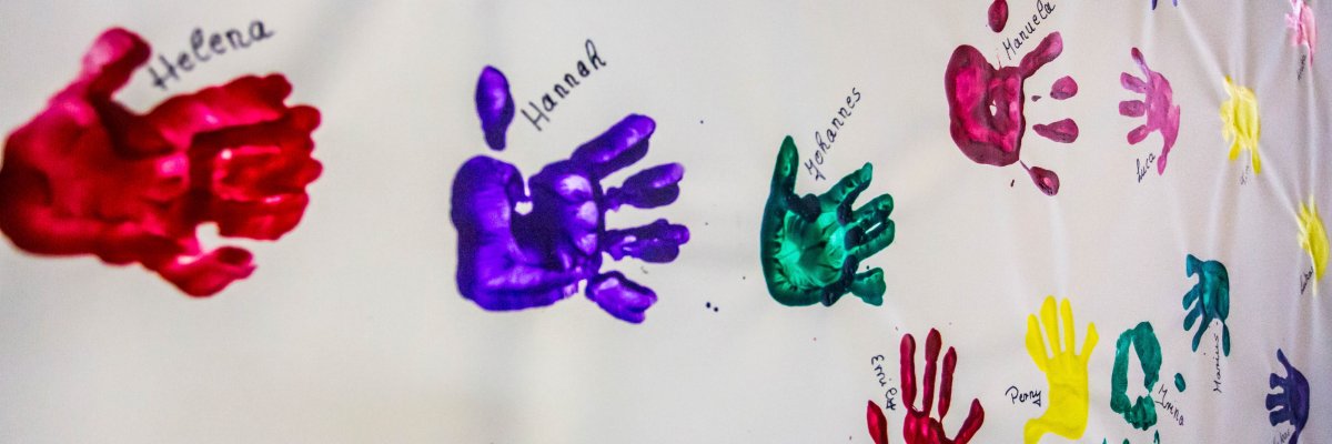 Colourful handprints on white canvas