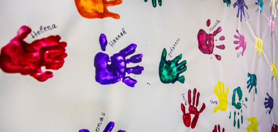 Colourful handprints on white canvas