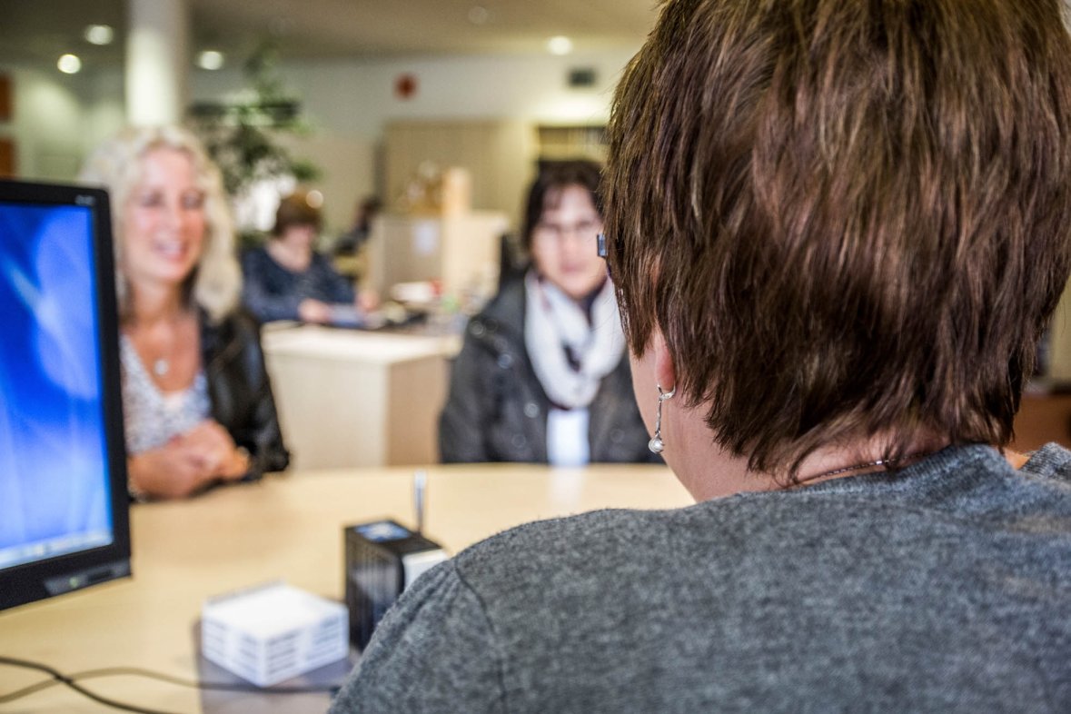 Clerk at the registration office talks to two customers