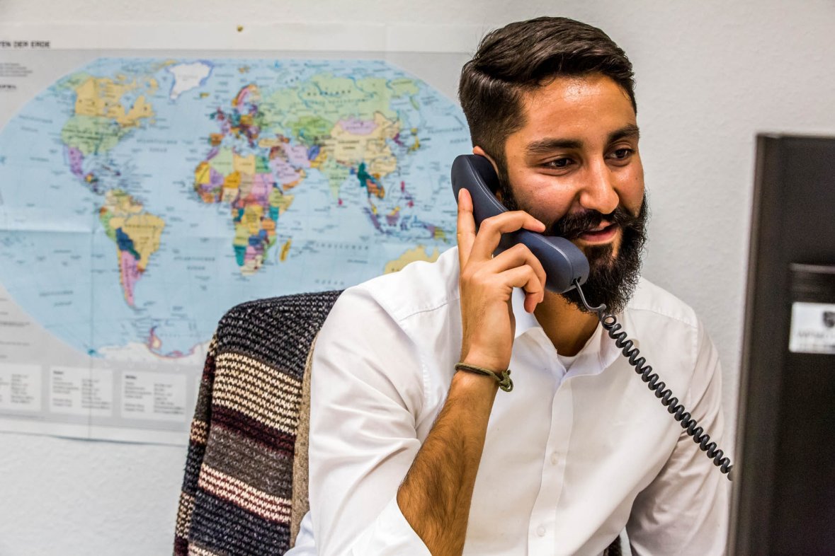 Employee telephones in front of world map