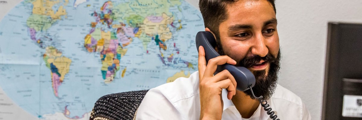 Employee telephones in front of world map