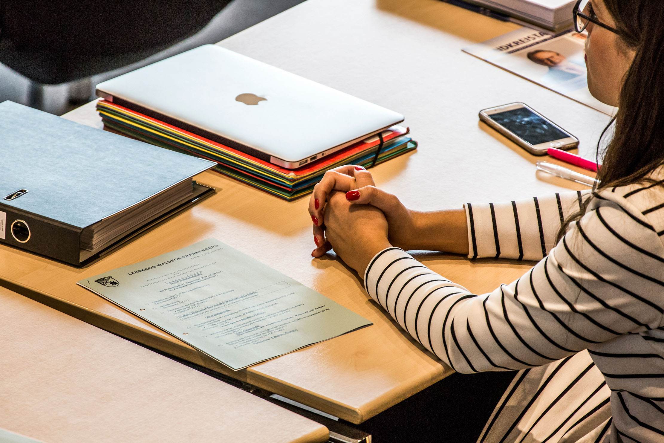 Woman sitting at a table with meeting documents
