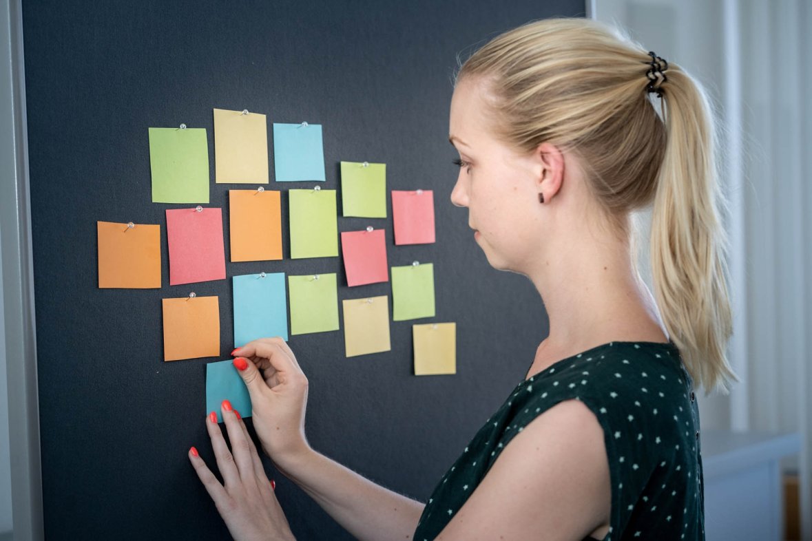 Young woman with notes on a pin board