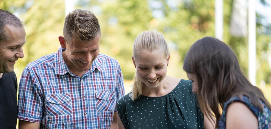 Four people looking at an iPad