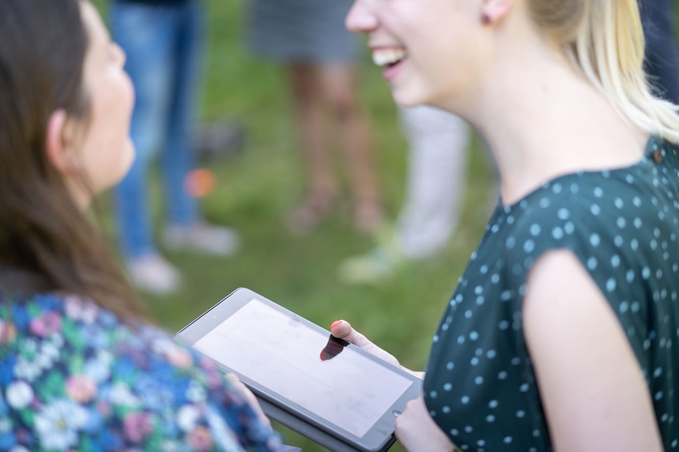 Two young women laughing with tablet in one woman's hand