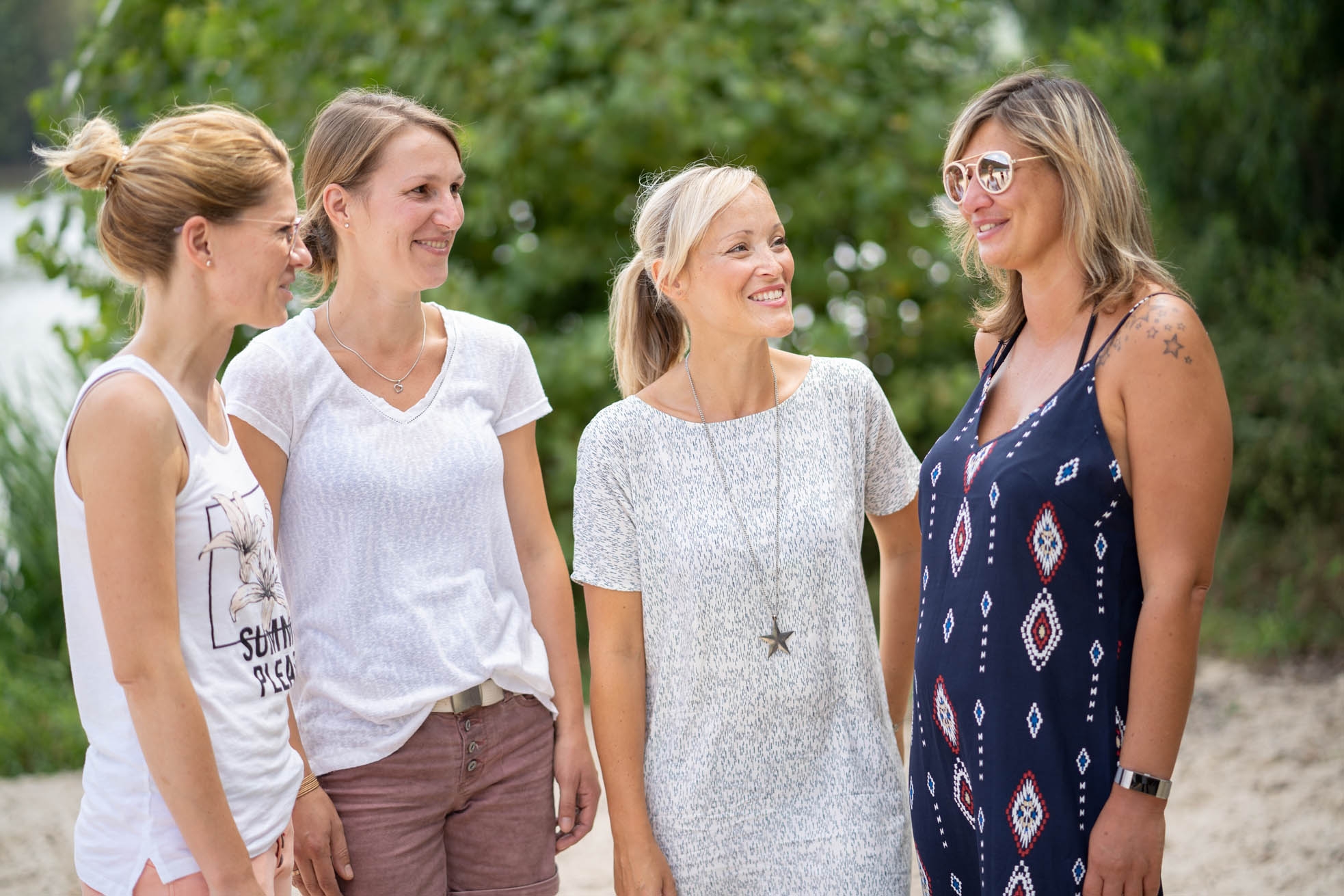 Four young women in summer dresses stand together