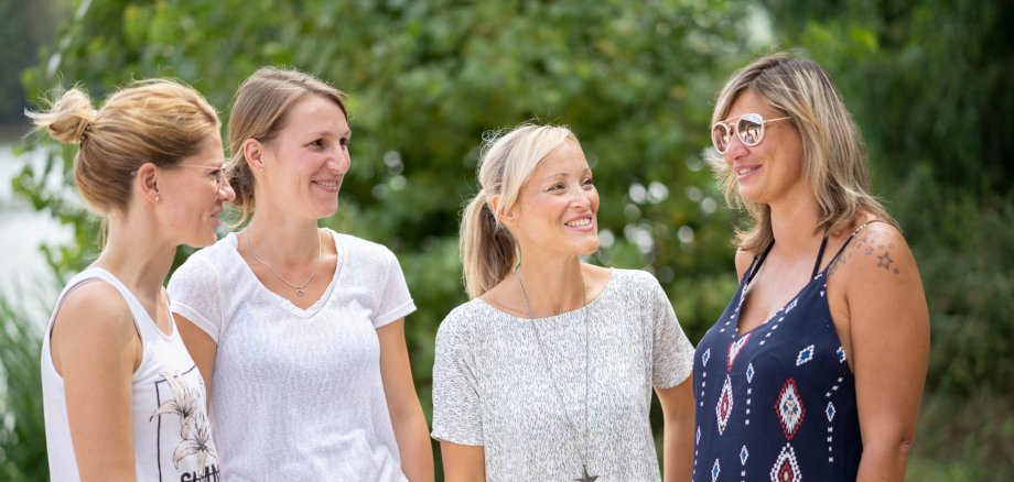 Four young women in summer dresses stand together