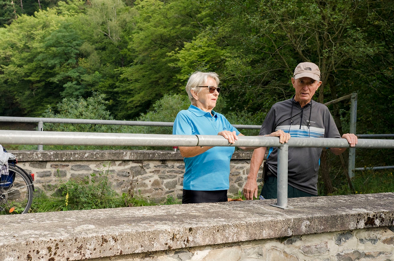 Seniors Senior couple in cycling clothes standing by a wooden railing