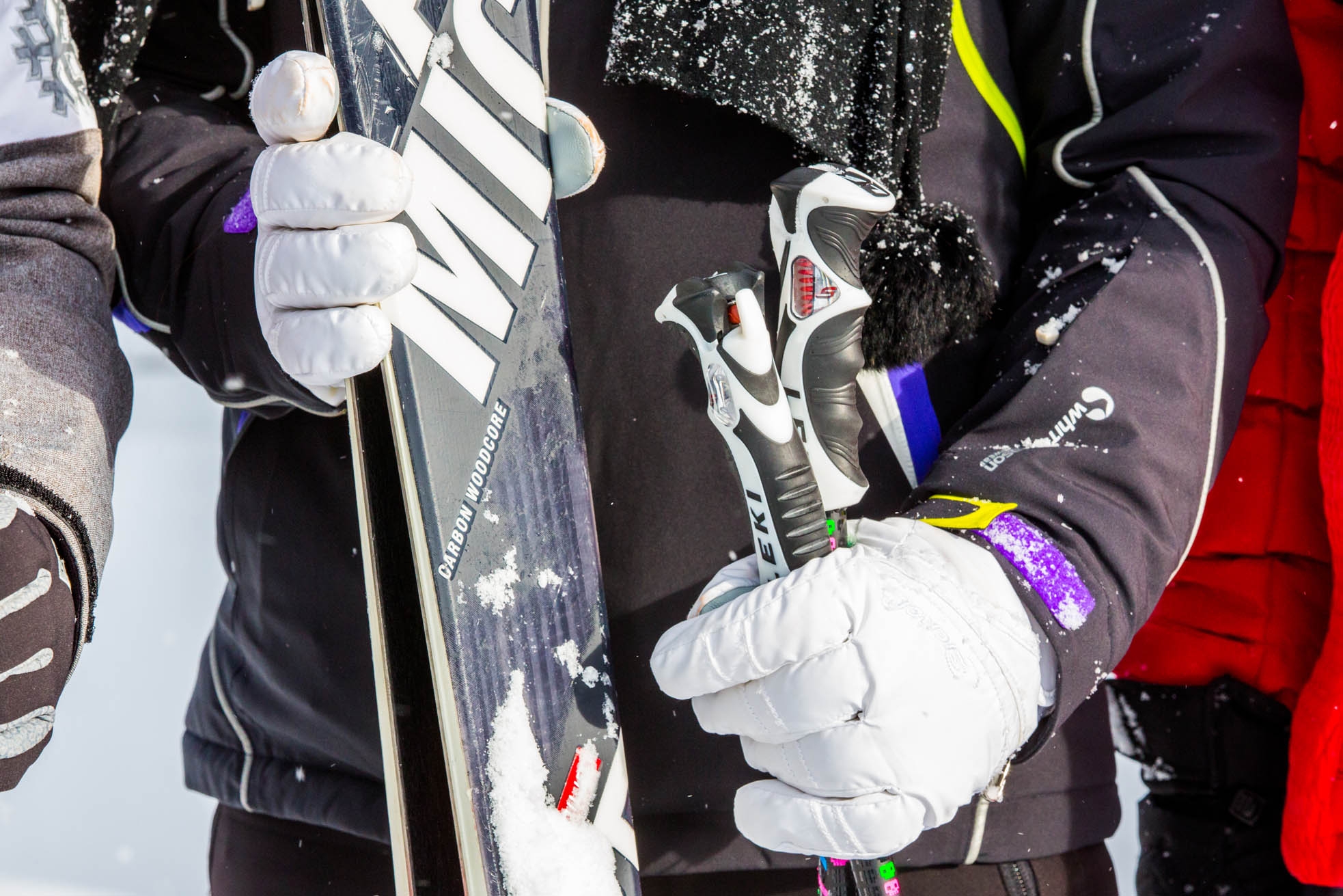 Winter Man in ski clothes holding skis and ski poles