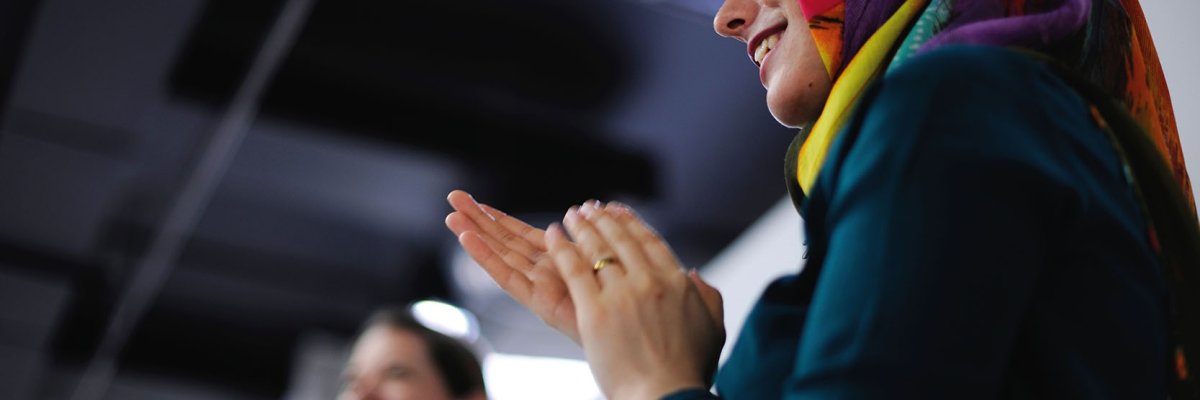 Smiling and clapping woman with headscarf