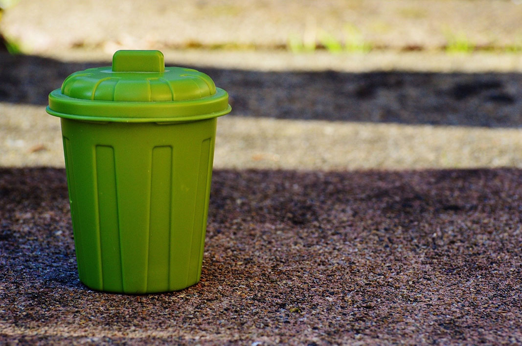 Green dustbin on a road