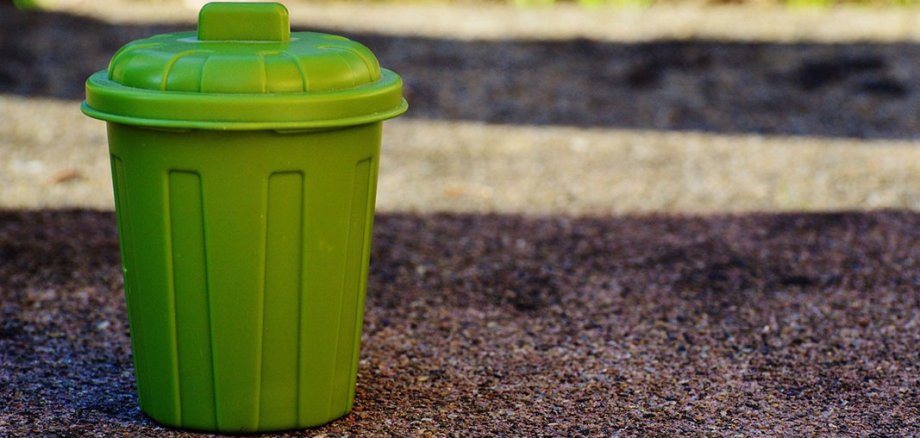 Green dustbin on a road