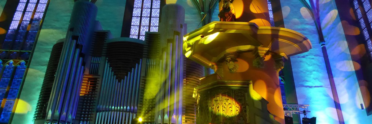 Green, blue and yellow illuminated organ in a Gothic hall church