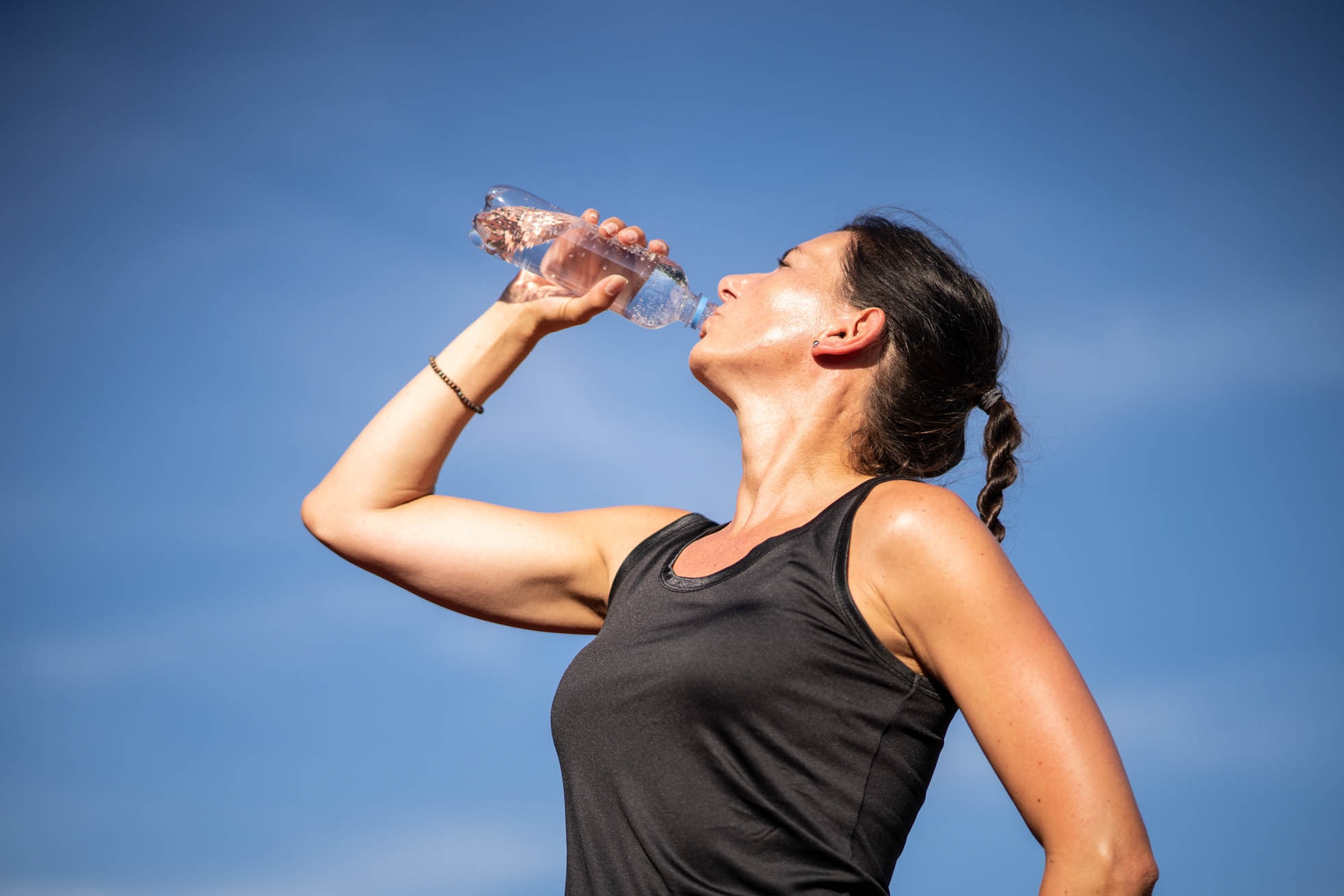 Woman in sportswear drinking from a water glass