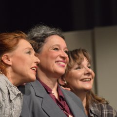 Half-length portrait of three laughing middle-aged women