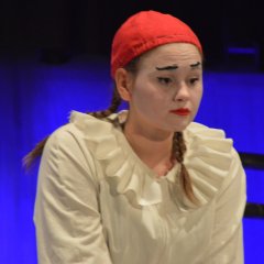 Bust portrait of a sad girl dressed in white with a tight pink cap