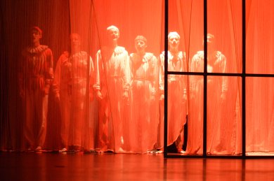 Theatre week Korbach_rohestheater Orange illuminated group of people, blurred, half hidden behind a frame on the right