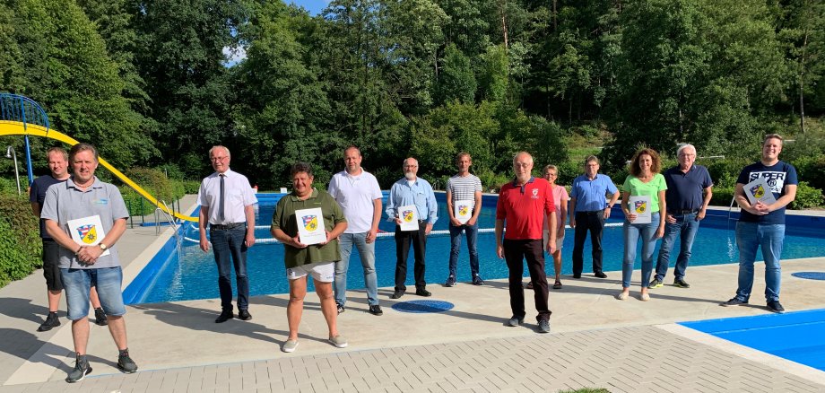 District Administrator Dr. Reinhard Kubat and Carsten Habermann from the Department of Sport and Youth Work together with the representatives of the outdoor swimming pool clubs from Marienhagen, Mengeringhausen, Vasbeck, Rhoden, Ehringen and the host Landau at the handing over of the notification.