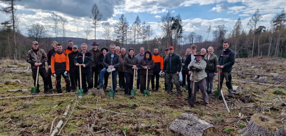 District Administrator Jürgen van der Horst, Hendrik Block and the participants of the Wild Forest Dialogue hold the shovels for planting the tree seedlings.