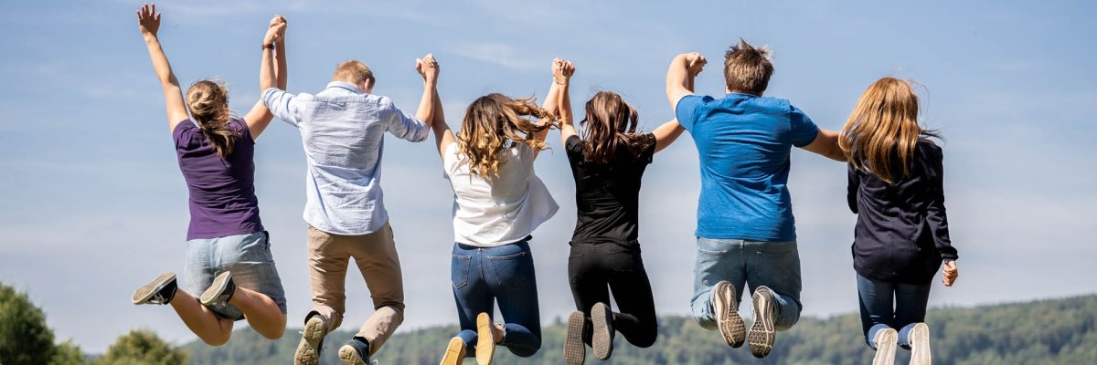 پرش هوایی شش نوجوان دستهای هم را گرفتهاند و از پشت به هوا میپرند.