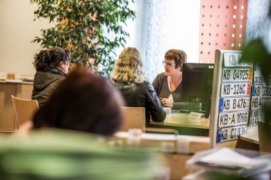 Працівник реєстраційної служби розмовляє з двома клієнтами