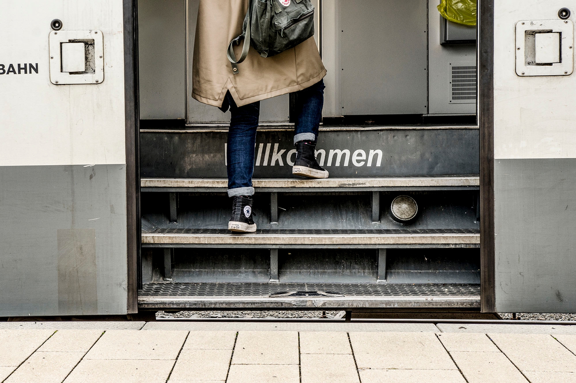 Einstiegsbereich eines Zuges mit Beinen einer einsteigenden Person