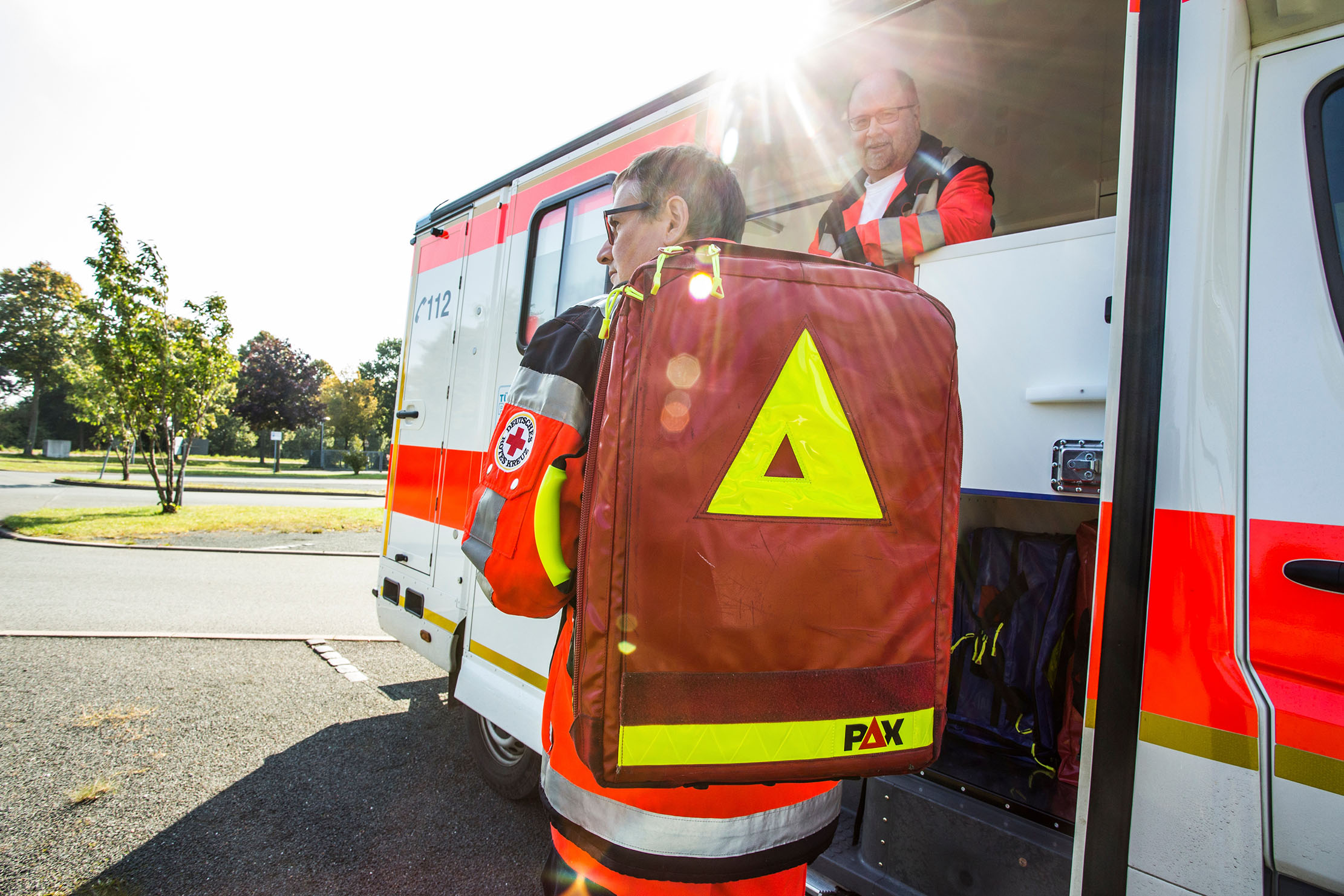 Rettungssanitäter Rettungssanitäter mit Notfallrucksack verlässt einen Rettungswagen